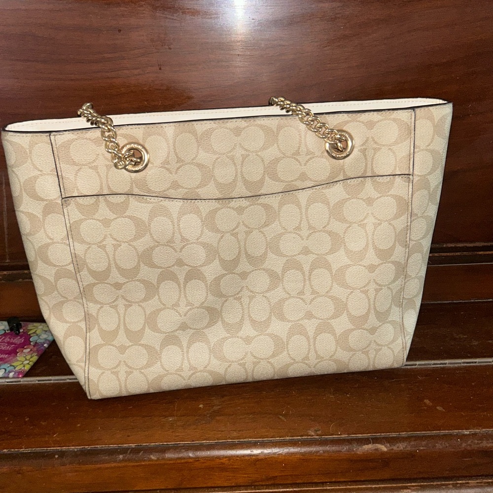 Beautiful gently used Coach large tote. Has a missing rivet on the zipper